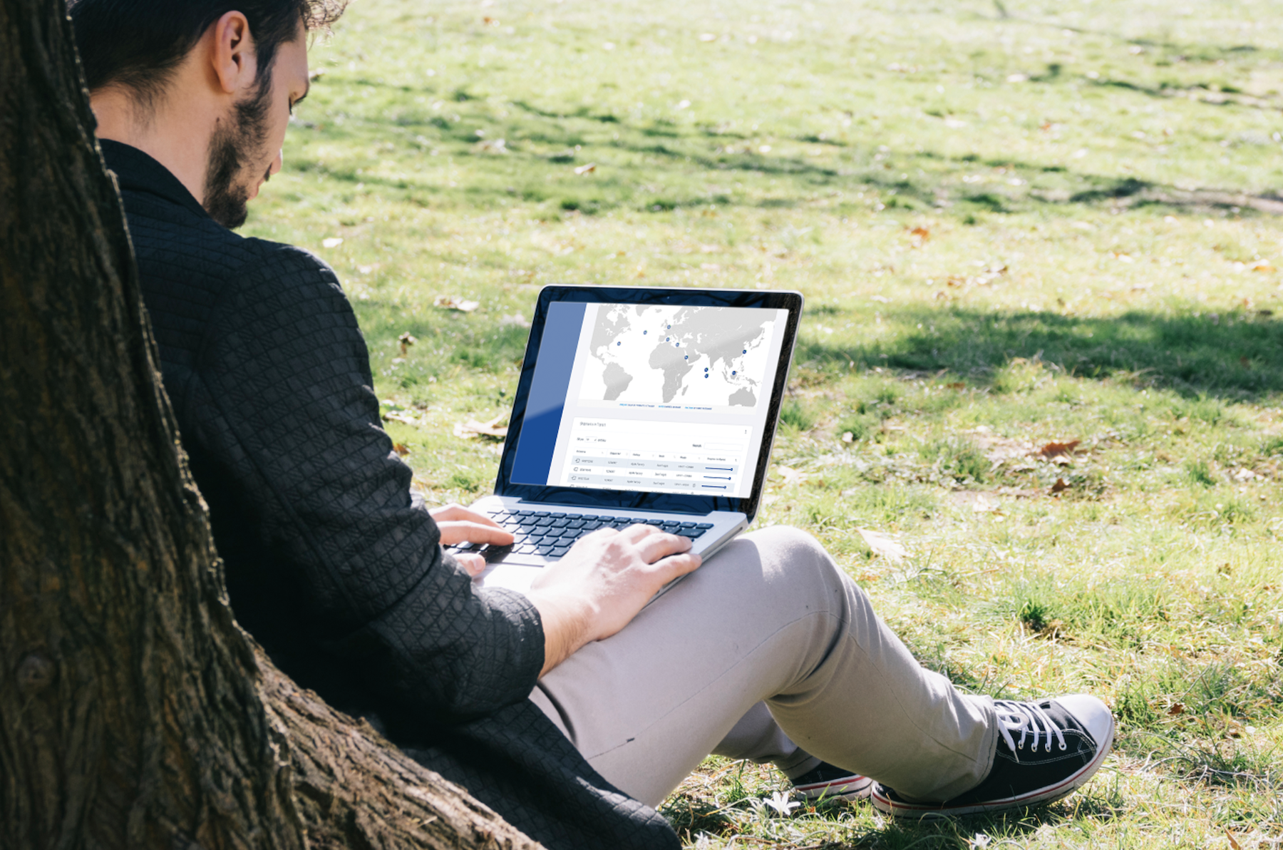 Man using HaulHub Logisticson a laptop whilst sitting in a park